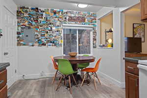 Dining room with light wood-type flooring and electric panel