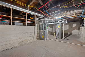 Unfinished below grade area featuring heating unit and water heater