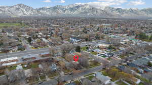 Aerial view of property and surrounding area featuring nearby suburban area and a mountainous background