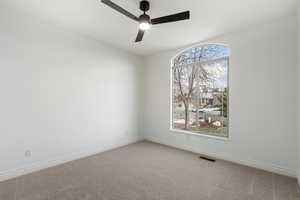 Spare room featuring ceiling fan and carpet floors