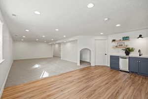 Bar with light countertops, open shelves, recessed lighting, blue cabinetry, and light colored carpet