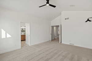 Primary Bedroom with light colored carpet, high vaulted ceiling, ceiling fan, and connected bathroom