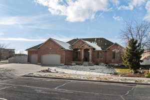 View of front facade featuring brick siding, driveway, an attached garage, and roof with shingles