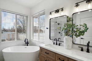 Full bath featuring double vanity, a soaking tub, and a shower stall