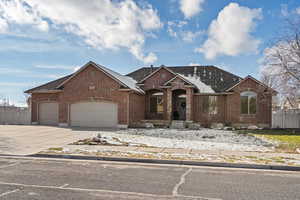 View of front of property with brick siding, driveway, an attached garage, and a shingled roof