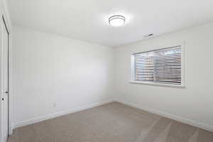 Unfurnished room featuring a textured ceiling and carpet