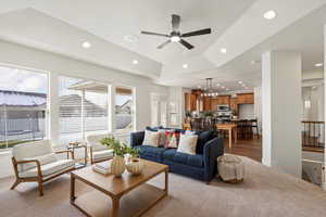 Living area with light carpet, recessed lighting, ceiling fan, and a chandelier