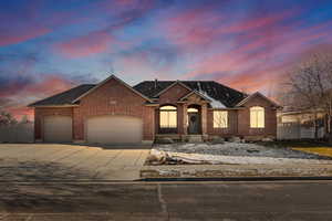 View of front of property featuring driveway, a garage, brick siding, and a shingled roof