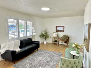 Living area with light wood finished floors and a textured ceiling