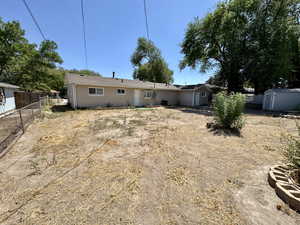 Rear view of house with a storage unit