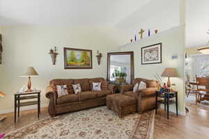 Living room featuring vaulted ceiling and baseboards