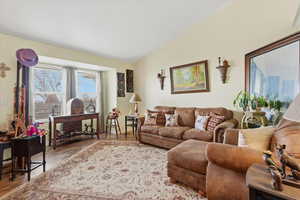 Living room featuring vaulted ceiling and wood finished floors