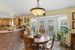 Dining space featuring french doors and lofted ceiling