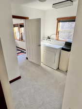 Laundry area featuring light colored carpet and washer and clothes dryer