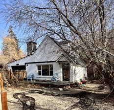 Unfinished property featuring a chimney and brick siding