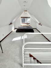 Carpeted bedroom featuring vaulted ceiling and baseboards