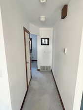 Hallway featuring baseboards and carpet