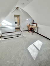 Bedroom with vaulted ceiling and carpet flooring