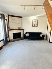 Living area featuring a fireplace, and light carpet