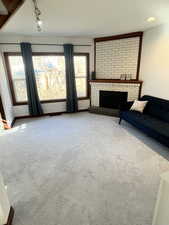 Unfurnished living room with carpet floors and brick fireplace.