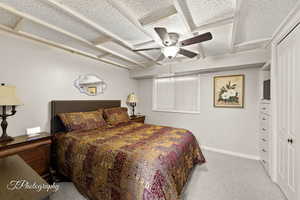 Bedroom with light colored carpet and a ceiling fan