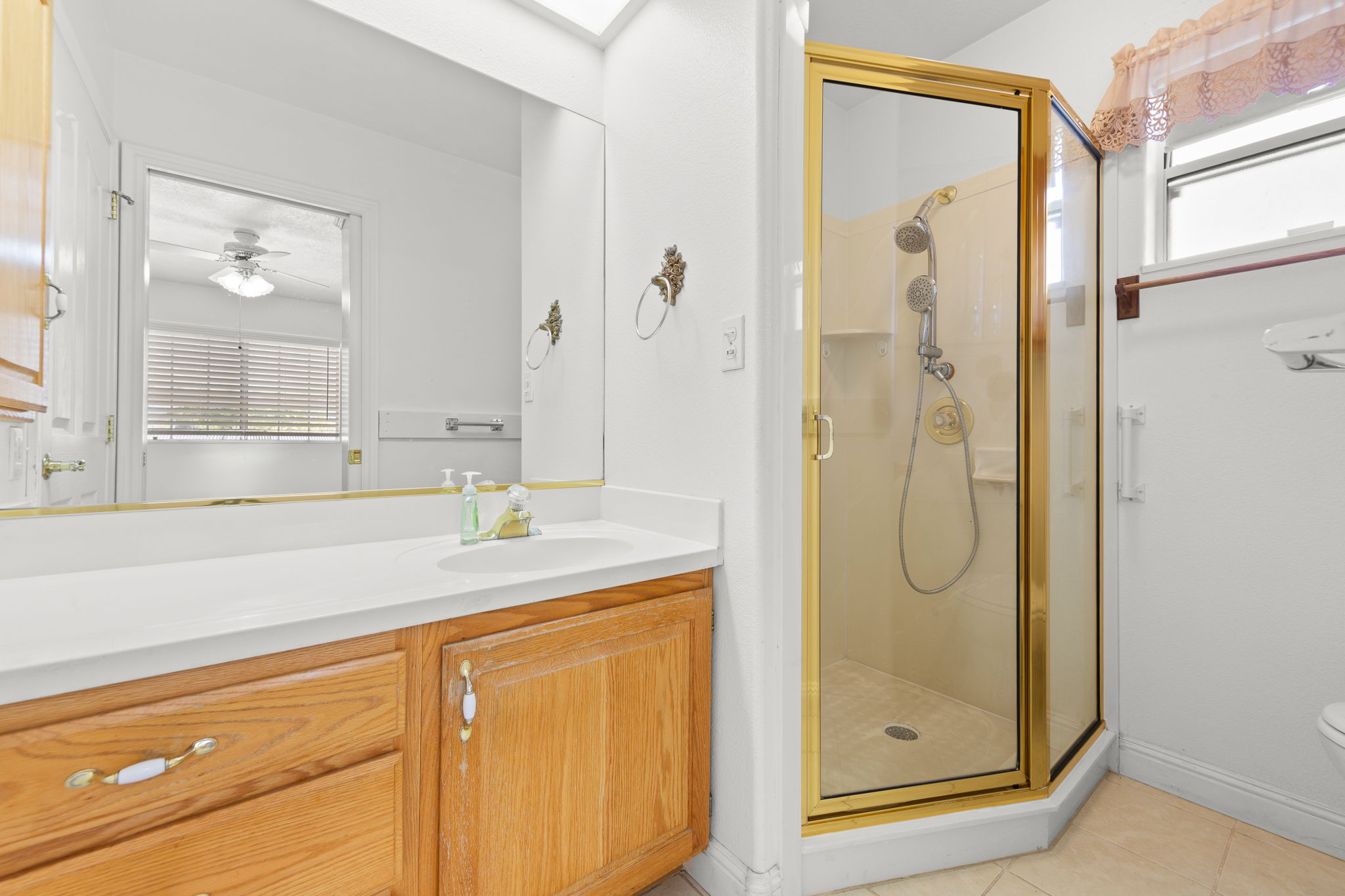 Full bathroom with plenty of natural light, vanity, a shower stall, and light tile patterned floors