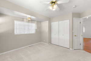 Unfurnished bedroom with light colored carpet, a closet, and ceiling fan