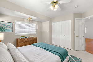 Carpeted bedroom featuring a closet and a ceiling fan