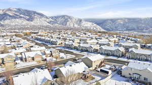 Snowy aerial view of home with mountain view