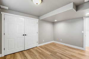 Bedroom with light wood-style flooring and large closet and window
