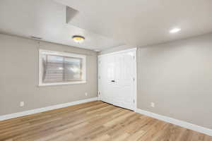 Bedroom with light wood-style flooring and large closet and window