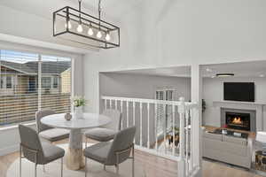 Dining area featuring light wood-style floors and a lit fireplace