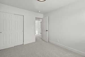 Unfurnished bedroom featuring a closet and carpet flooring