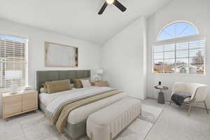 Carpeted bedroom with high vaulted ceiling and a ceiling fan