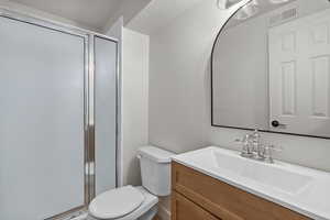 Full bath featuring vanity, a shower stall, and a textured ceiling