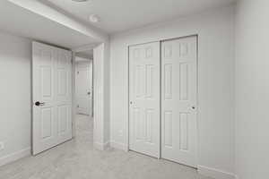 Unfurnished bedroom featuring light colored carpet and a closet