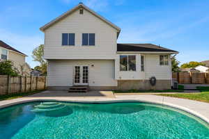 Back of house featuring a patio area, a fenced backyard, french doors, and a shingled roof