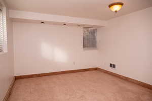 Carpeted empty room featuring baseboards