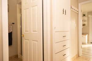 Corridor with light tile patterned floors and baseboards