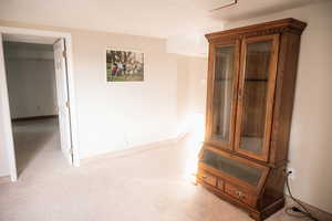 Hallway featuring carpet and baseboards