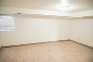 Spare room featuring a textured ceiling and carpet