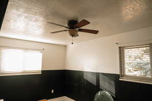 Empty room featuring a textured ceiling and a ceiling fan