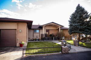 View of front facade featuring brick siding, concrete driveway, stucco siding, an attached garage, and roof with shingles