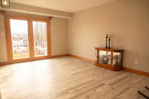 Unfurnished living room with light wood-style floors and french doors