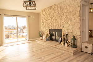 Unfurnished living room with wood finished floors, a fireplace, and a textured ceiling