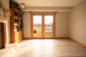 Doorway to outside with wood finished floors and baseboards
