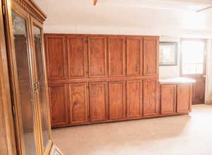 Interior space with brown cabinets and light carpet