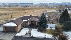 View of front facade featuring a fenced front yard, a mountain view, driveway, and an attached garage