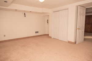 Unfurnished bedroom featuring a textured ceiling, a closet, and light carpet