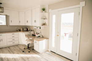 Office with built in study area and light wood finished floors